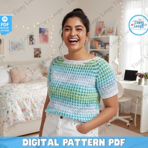 Puede incluir: Un top de ganchillo de manga corta en tonos azules, verdes y blancos. El top tiene un patrón texturizado y se combina con pantalones blancos. La imagen también incluye el texto "DIGITAL PATTERN PDF".