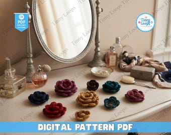 Puede incluir: Una colección de aplicaciones de flores de ganchillo de varios colores, incluyendo rojo, azul y dorado, se colocan sobre una cómoda. La imagen incluye un espejo, frascos de perfume y el texto "DIGITAL PATTERN PDF".