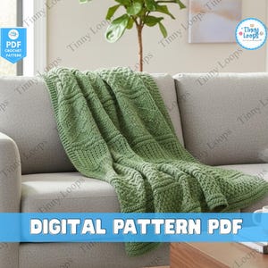 May include: A green crocheted blanket with a textured pattern is draped over a gray sofa. The blanket has a detailed stitch design. The words "DIGITAL PATTERN PDF" are displayed in white text on a blue banner. A white mug and a book are on a wooden table.