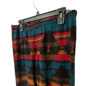 May include: A pair of leggings with a colorful southwestern-style geometric pattern in shades of red, orange, brown, teal, and black.