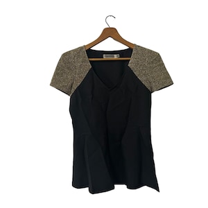 May include: A black short-sleeved dress with gold sequin detailing on the shoulders. The dress has a v-neck and a flared skirt.