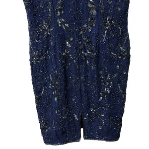 May include: A navy blue sleeveless dress with a floral pattern and silver sequins.