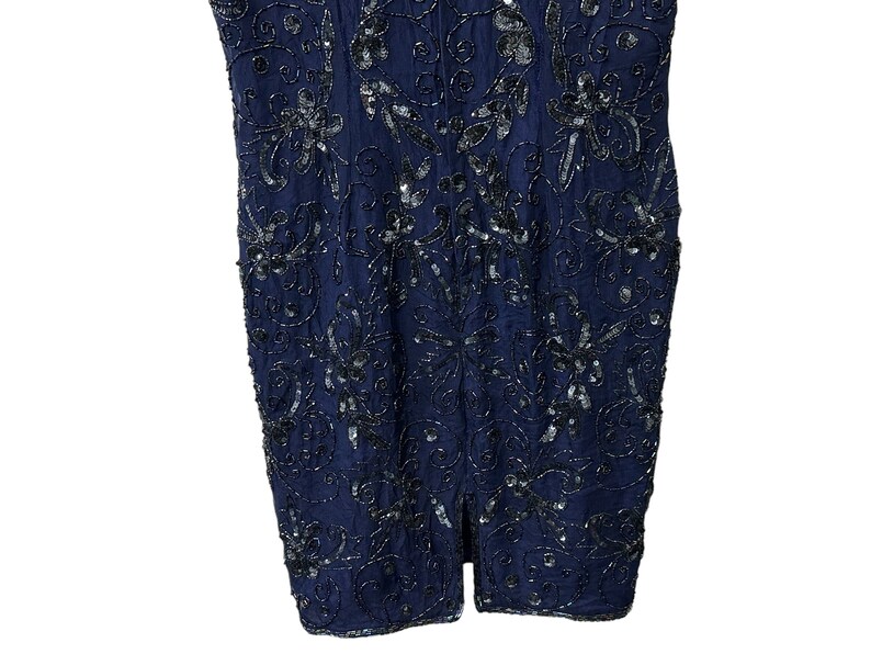 May include: A navy blue sleeveless dress with a floral pattern and silver sequins.