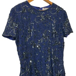 May include: A navy blue sequined dress with a floral pattern. The dress has short sleeves and a round neckline.