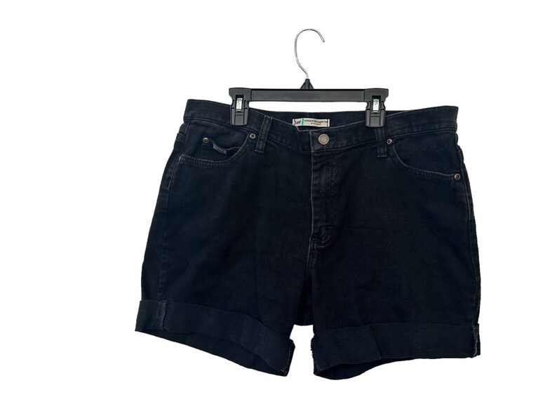 May include: Black denim shorts with a cuffed hem. The shorts have a button and zipper closure and belt loops.