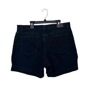 May include: Black denim shorts with a cuffed hem. The shorts have a classic five-pocket design.
