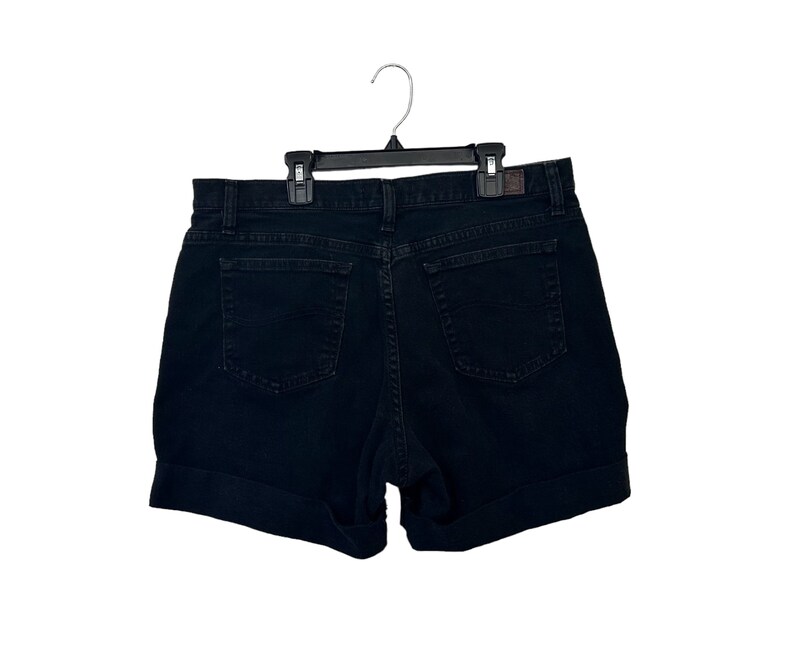 May include: Black denim shorts with a cuffed hem. The shorts have a classic five-pocket design.
