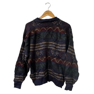 May include: A blue, brown, and red patterned sweater with a long sleeve and a crew neck.