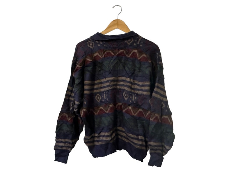 May include: A blue, brown, and red patterned sweater with a long sleeve and a crew neck.