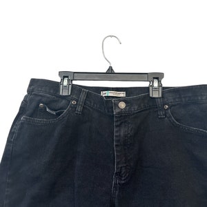 May include: Black denim jeans with a single front pocket and a waistband with belt loops.