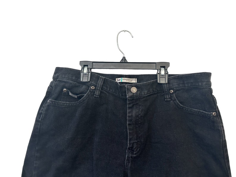 May include: Black denim jeans with a single front pocket and a waistband with belt loops.