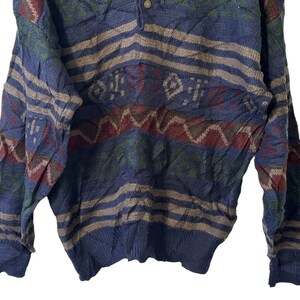 May include: A blue, green, red, and brown patterned sweater with a button closure at the neck.