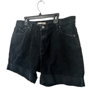 May include: Black denim shorts with a cuffed hem. The shorts have a small label that reads "Natural Straight Leg" in white text.