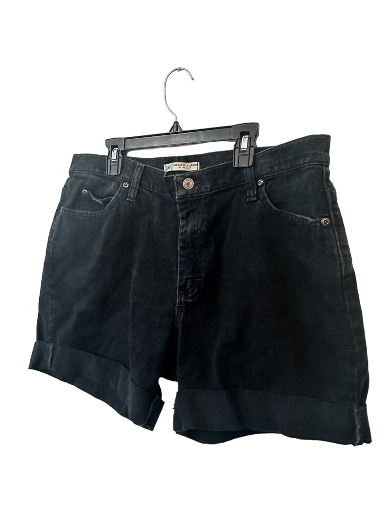 May include: Black denim shorts with a cuffed hem. The shorts have a small label that reads "Natural Straight Leg" in white text.