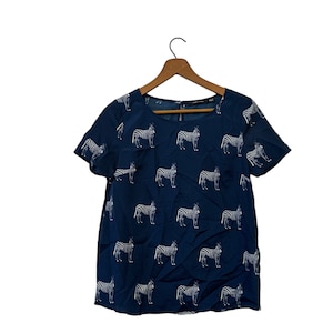 May include: A navy blue short-sleeved shirt with a white zebra print.