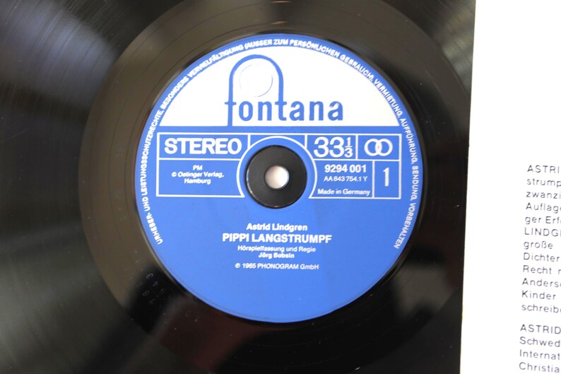 May include: A black vinyl record with a blue and white label featuring the text "fontana" and "PIPPI LANGSTRUMPF". The record is a 33 1/3 RPM stereo recording, made in Germany.
