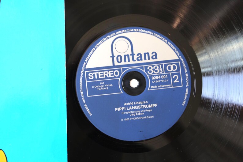 May include: A black vinyl record with a blue and white label featuring the text "fontana" and "PIPPI LANGSTRUMPF". The record is a stereo 33 1/3 RPM album, made in Germany.