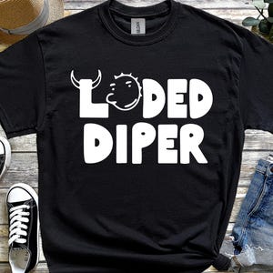 May include: Black t-shirt featuring the white text "LOADED DIPER" and a cartoon illustration. The shirt is a crew neck and is paired with denim shorts and black and white trainers.