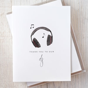 Może przedstawiać: Biała kartka z czarno-czerwoną ilustracją słuchawek z nutami. Pod ilustracją znajduje się tekst "Dziękujemy naszemu dj'owi".