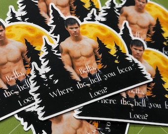 Op de afbeelding: Een verzameling uitgestanste stickers met een ontblote man voor een gele maan en zwarte bomen. De stickers hebben de tekst "Bella, where the hell you been, Loca?" in het wit.