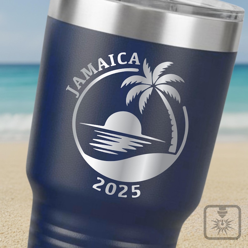 May include: A navy blue insulated travel mug with a silver lid. The mug has a white graphic of a palm tree, sun, and ocean scene with the word "JAMAICA" and the year "2025" in a circular design.
