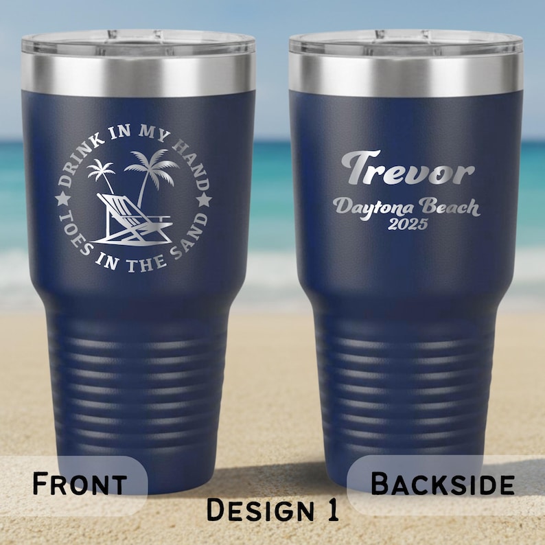 May include: Navy blue insulated travel mug with a silver rim and lid. The front displays a beach scene with text: "DRINK IN MY HAND, TOES IN THE SAND." The back has the name "Trevor" and "Daytona Beach 2025."