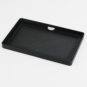 May include: A rectangular black plastic tray with a slightly raised edge and a small, semi-circular cutout on one side. The tray has a matte finish and appears to be empty. The overall design is simple and functional.