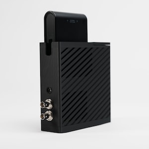 May include: A black electronic device with a rectangular body and a top component. The body has diagonal lines and two silver connectors. The top component has text that reads "ANTENNA KEEP CLEAR".