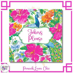 May include: Square print with a floral and peacock design. The print features bright pink hibiscus flowers, orange and blue flowers, and a peacock. The text "Jokers Please" is in a white frame. The words "Peacock Luau Chic" are at the bottom.