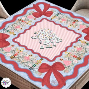 Pu&ograve; includere: Un tappetino da mahjong quadrato con sfondo a quadretti vichy azzurro, bordo ondulato rosso e grandi fiocchi rossi su ogni angolo. La stampa include figure di schiaccianoci e ballerine. Un mucchio di tessere bianche &egrave; al centro.