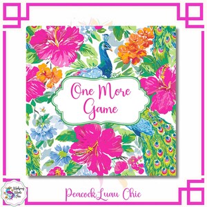 May include: Square print with a floral and peacock design. The print features bright pink hibiscus flowers, orange blossoms, and blue peacocks. The text "One More Game" is in a white frame. The words "Peacock Luau Chic" are at the bottom.