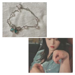 Könnte beinhalten: Ein silbernes Armband mit einem Schmetterlingsanhänger, der rosa und türkisfarbene Akzente aufweist. Das Armband ist mit kleinen, klaren und rosa Perlen verziert. Der Schmetterlingsanhänger ist das zentrale Element des Schmucks.