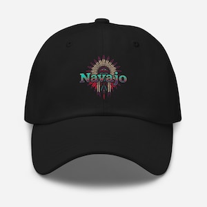 May include: Black baseball cap featuring the word "Navajo" in turquoise and purple, with a Native American headdress design in the center. The headdress includes feathers in red, yellow, and turquoise.