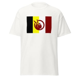 May include: White t-shirt featuring a graphic design with a black, yellow, and red flag-like pattern. The design includes a red hand making a peace sign and a profile of a person's face.