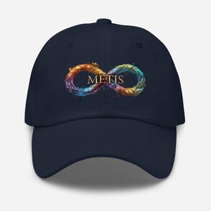 May include: A navy blue baseball cap with a colourful infinity symbol design and the word "METIS" in gold. The infinity symbol has orange, yellow, blue, and green accents. The cap has a curved peak and a structured crown.