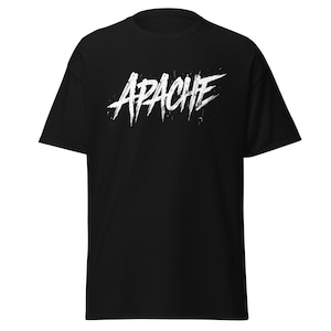 Puede incluir: Camiseta negra con la palabra "APACHE" en letras blancas desgastadas en el pecho. El texto tiene una fuente de estilo grunge, con una apariencia ligeramente áspera y texturizada. La camiseta es de cuello redondo básico.