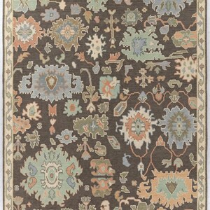 Peut inclure: Tapis rectangulaire avec un fond marron fonc&eacute; et une bordure cr&egrave;me. Le motif r&eacute;p&eacute;t&eacute; pr&eacute;sente des formes florales et g&eacute;om&eacute;triques en bleu, vert, p&ecirc;che et cr&egrave;me. Le design du tapis est complexe.