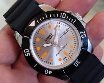 Reloj de pulsera Seiko 5 vintage para hombre, automático, estilo buceo, esfera plateada, bisel giratorio negro, día y fecha, fabricado en Japón. 40 mm