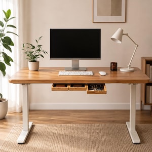 May include: A height-adjustable desk with a light brown wooden top and white metal legs. The desk features three small, integrated wooden drawers under the surface, a computer monitor, a white keyboard, a white mouse, and a white desk lamp.