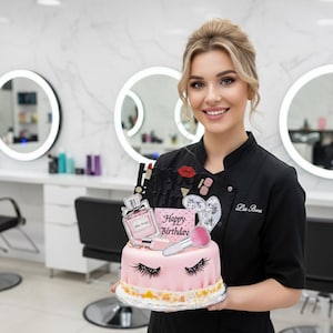 May include: A pink birthday cake decorated with makeup-themed toppers, including a perfume bottle, lipstick, and a makeup brush. The cake has a "Happy Birthday" sign and decorative eyelashes. The cake is held by a person in a black uniform.