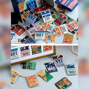 Op de afbeelding: Een verzameling vintage bagagelabels in verschillende kleuren, waaronder blauw, oranje en groen. De labels bevatten luchthavencodes zoals JFK, LAX en BOS en worden weergegeven in een metalen doos en geregen op een touwtje. Retro reisthema.