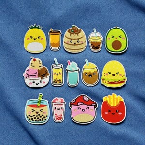 Może przedstawiać: Kolekcja kolorowych naszywek spożywczych w stylu kreskówkowym, w tym ananas, napoje, naleśnik, awokado, lody, burger, frytki i grzyb. Każda naszywka ma uśmiechniętą twarz i jest obrysowana na czarno.