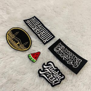 May include: A collection of five embroidered patches including a circular black and gold Kaaba design, two rectangular black patches with white Arabic calligraphy, a small triangular watermelon slice, and a black patch with white text reading Tawhid First.