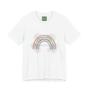 May include: White t-shirt featuring a watercolor rainbow design in pastel colors. The rainbow arches over the text "Hope in Color". The shirt has a classic crew neck and short sleeves.