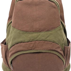 K&ouml;nnte beinhalten: Ein Rucksack aus Segeltuch mit einem farblich abgesetzten Design in Braun und Olivgr&uuml;n. Die Tasche verf&uuml;gt &uuml;ber ein gro&szlig;es Hauptfach, eine kleinere Rei&szlig;verschlusstasche auf der Vorderseite und zwei Seitentaschen aus strapazierf&auml;higem Stoff.