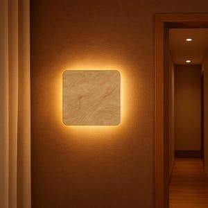 Pode incluir: Uma luminária de parede quadrada com uma borda quente e brilhante. A face da luz tem um padrão bege marmorizado. É montada em uma parede marrom, com um vislumbre de uma porta e uma cortina ao fundo.