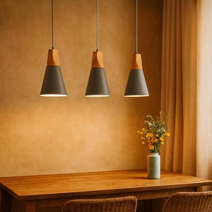 Op de afbeelding: Drie moderne hanglampen met een houten bovenkant en een donkergrijze conische kap hangen boven een houten tafel. Een vaas met bloemen staat op de tafel. De lampen hangen aan het plafond.