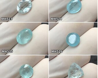 May include: A collection of six aquamarine gemstones in various shapes, including oval, round, and triangular cuts. Each gem is a light blue color and displayed against a white background. The text "MH523", "MH524", "MH525", "MH526", "MH527", and "MH528" is visible.