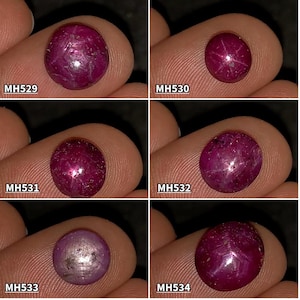 Puede incluir: Seis gemas ovaladas de color rojo intenso, cada una sostenida entre dedos. Las superficies pulidas de las piedras muestran patrones en forma de estrella. Cada gema está identificada con un código: MH529, MH530, MH531, MH532, MH533 y MH534. Las gemas son de un rojo oscuro.