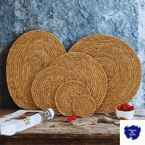 Könnte beinhalten: Ein Set aus sechs gewebten, runden Tischsets und Untersetzern in verschiedenen Größen. Die Tischsets und Untersetzer bestehen aus einem natürlichen, hellbraunen Material. Sie liegen auf einer Holzoberfläche, neben einer Schale mit Tomaten.